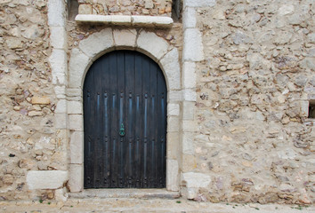 Fototapeta na wymiar Black door on stone wall