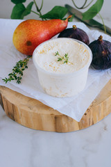Ricotta cheese with peach, figs and thyme on wooden board