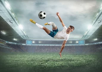 Foto op Canvas Soccer player on a football field in dynamic action at summer day © Andrii IURLOV
