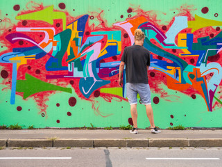 young man use his talent and feeling for art to apply this with various colors to a city wall