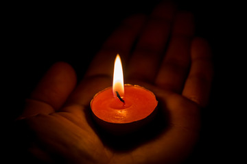 Burning candle on the palm

