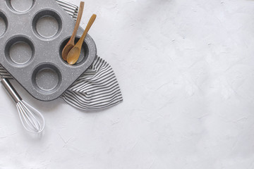 Kitchen utensils for baking - Cupcake metal mold, Whisk, wooden spoons on Crumpled Striped Napkin.