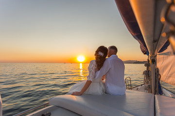 wedding couple travel on yacht at sunset