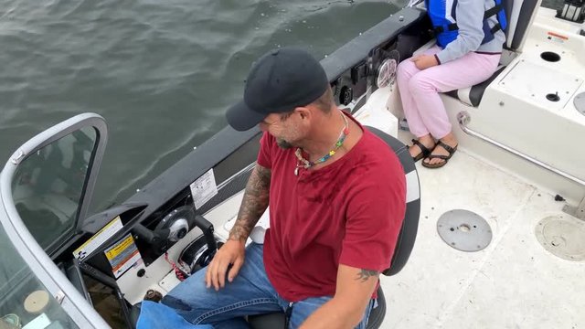 Man picking nose on boat in summer family trip