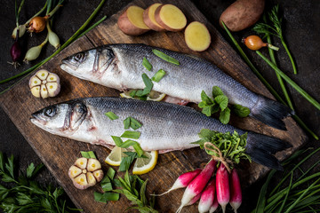 fish sea bass with vegetables potatoes, garlic and herbs, ingredients for cooking
