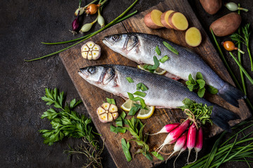 fish sea bass with vegetables potatoes, garlic and herbs, ingredients for cooking