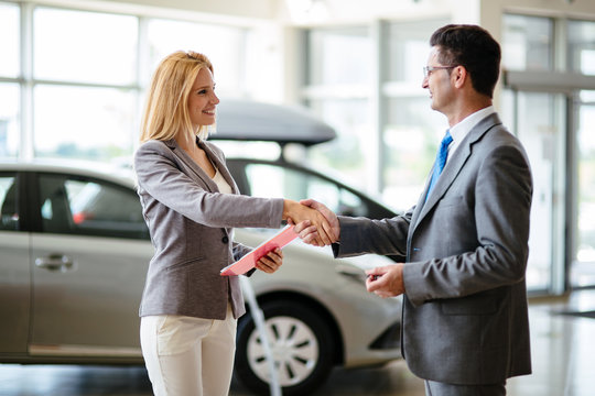 Successful businessman in a car dealership - sale of vehicles to customers