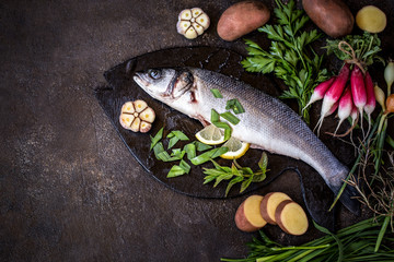 fish sea bass with vegetables potatoes, garlic and herbs, ingredients for cooking