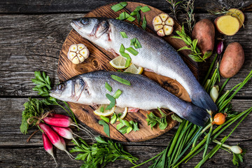 fish sea bass with vegetables potatoes, garlic and herbs, ingredients for cooking