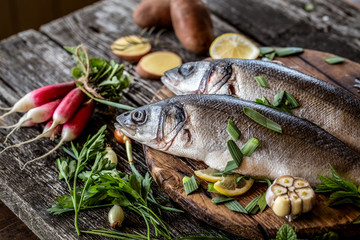 fish sea bass with vegetables potatoes, garlic and herbs, ingredients for cooking