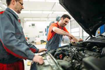 Fototapeta na wymiar Car mechanics working at automotive service center