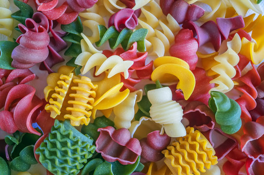 Mixed set of dry multi-colored Italian pasta on a white old wooden box. Background. Close up
