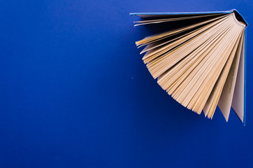 Open book in the up-right corner of a blue background