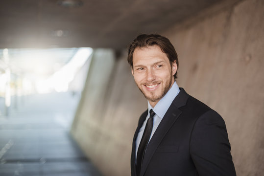 Portrait of smiling businessman in underpass