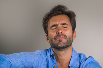 Obraz premium young attractive and handsome sad latin man sitting tired and depressed at home sofa couch feeling overwhelmed and worried suffering depression crisis and anxiety