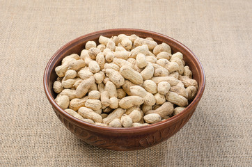 Peanuts in the peel on a light burlap.