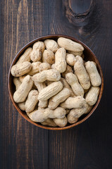Peanuts in the peel on a dark background.