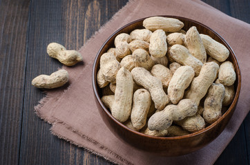 Peanuts in the peel on a dark background.