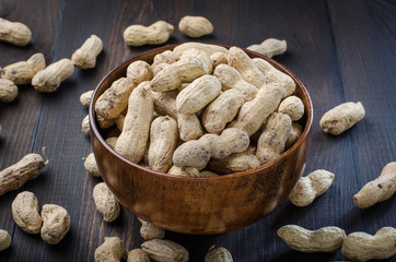 Peanuts in the peel on a dark background.