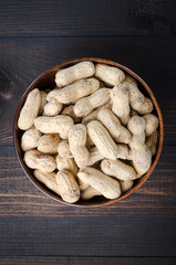 Peanuts in the peel on a dark background.