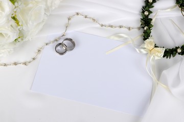wedding invitation - wedding rings and white roses with a blank wedding invitation