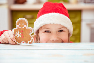 Beautiful girl child plays with ginger cookies. Concept of Christmas, New year