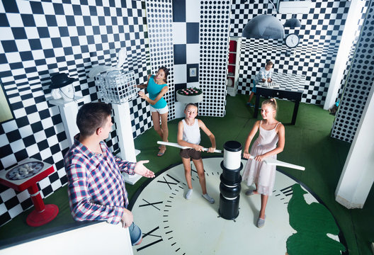 Family of five is having fun together in lost chessroom.