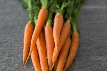 healthy eating, food, dieting and vegetarian concept - close up of carrot bunch on table