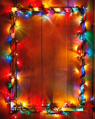 Christmas lights frame on wooden background