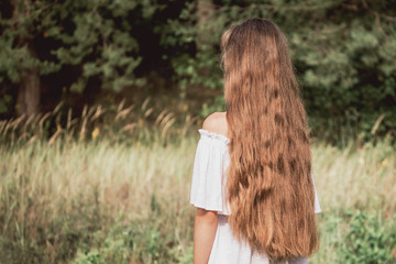 young girl european hipster with long and lovely hair looks at the forest, boho style, look back Summer and freedom concept.