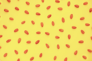 Nuts almonds on a yellow background, texture, pattern, top view, close-up, flatlay