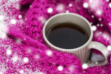 Obraz na płótnie Canvas season, drinks, christmas and winter holidays concept - close up of tea or coffee mug and knitted woolen scarf in snow