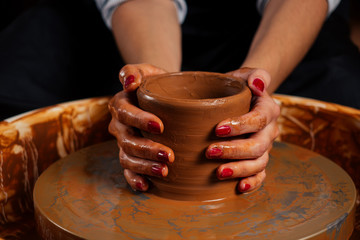 beautiful potter master woman molds from clay pot in mastre. female student sculptor works with clay on a Potter's wheel and at the table with the tools In workshop. inspiration and creativity