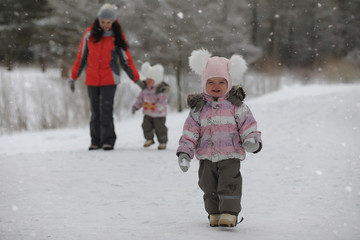 Fototapeta na wymiar Children walk in the park in winter. Winter forest a family with
