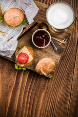 Mini burgers on wooden background