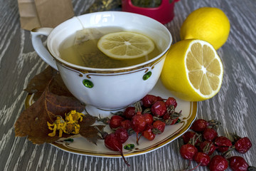 Tea with lemon in a white Cup. Red berries on the table.