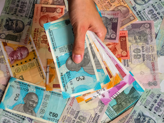Woman's hands holding indian notes. 10, 20, 50, 100, 200, 500 and 2000 Indian rupees, old and new notes.