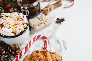 Winter hot drink. Christmas hot chocolate or cocoa with marshmallow, cookies   on white background with christmas decorations. Flat Lay.