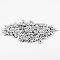 Metallic shiny shapeless mercury like balls are in a pile