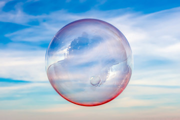 Colored soap bubble against the sky. Sky background and bubble.
