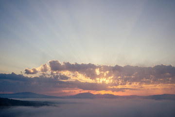 sunrise clouds on top of rocky mountain with misty ,mist peaks sunset landscape.