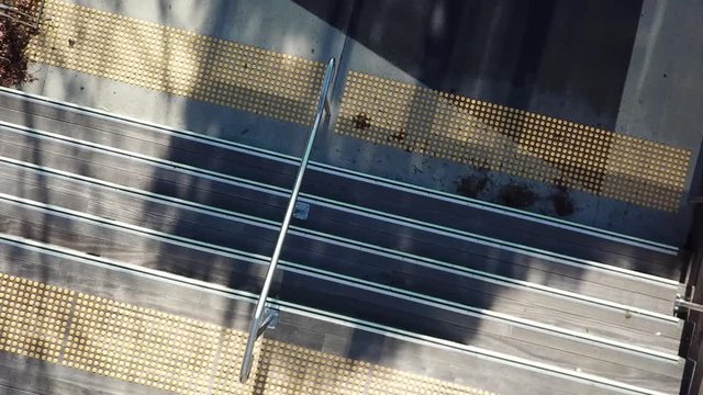 Close up birds eye view, drone footage of wood decking stairs with  Crome/metal railings, safety nosing and yellow anti slip bumps