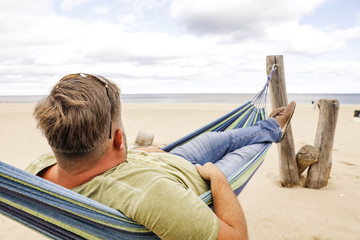 Beach and sea landscape with man on hammock. 