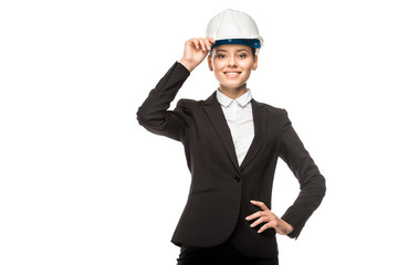 happy young female architect in helmet and suit looking at camera isolated on white