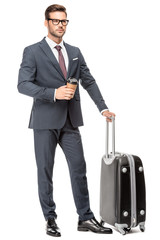 handsome young businessman with luggage and paper cup of coffee looking away isolated on white