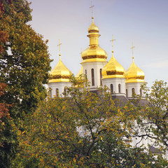 Fototapeta na wymiar Beautiful church in the park. Golden domes. Autumn