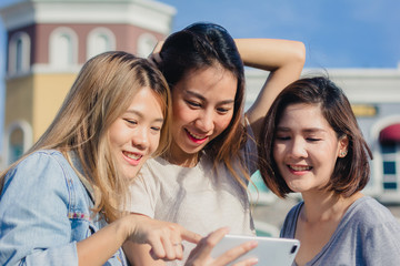 Obraz premium Attractive beautiful asian friends women using a smartphone. Happy young asian teenage at urban city while taking self portraits with her friends together with a smartphone.