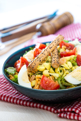 Salad of pasta, egg, smoked salmon tartare, salad and tomato, with a citrus vinaigrette sauce.