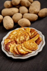 delicious golden potato pancakes on an old wooden black table in the kitchen