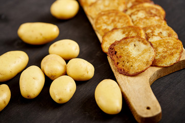 delicious golden potato pancakes on an old wooden black table in the kitchen